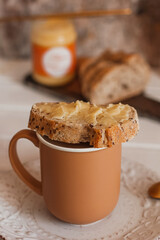 Ghee butter in glass jar and sliced bread on table. Healthy eating, breakfast