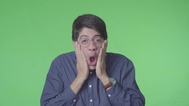 Hombre muy sorprendido gritando muy alegre con fondo verde