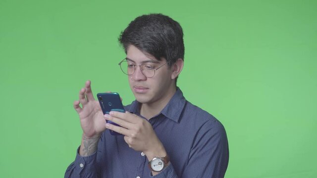 Hombre latino recibiendo llamada telef&oacute;nica con fondo verde