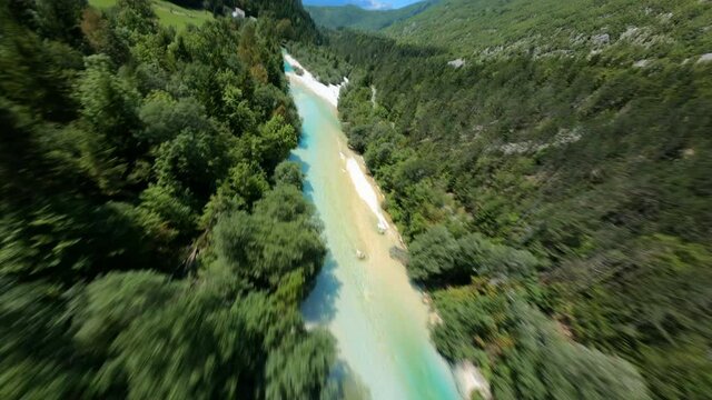 FPV aerial footage crossing a crystal clear river very fast in a beautiful day in Soca Valley, Slovenia