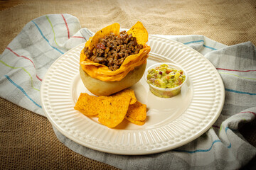 Baked potato with chilli meat with nachos and guacamole, mexican food