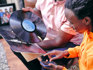 Grandfather and granddaughter looking at vinyl records