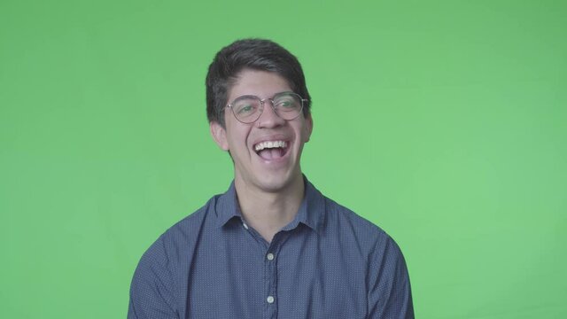 hombre latino riendose muy fuerte con fondo verde