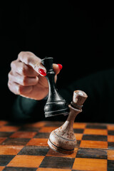 Woman player playing board intelligence game - wooden chess. Lady wins round with an opponent....