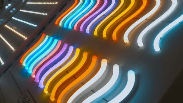 A lot of modern, economical, eco-friendly flexible led neon glowing on the stand at the exhibition. Shot in motion. Closeup