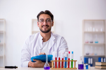 Young male chemist working at the lab