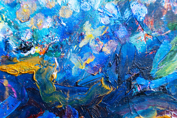 Multicolored large strokes of oil paint in blue, red and yellow shades on canvas, close up. Creative conception of abstract and bright background