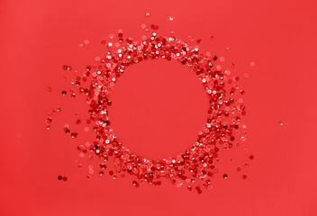 Sequins red confetti lined in round frame red background. Abstract festive composition place for text