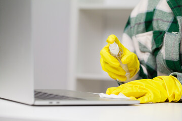 Professional cleaning lady cleans table using a sponge and spray