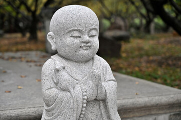 Fototapeta na wymiar A little monk statue in a Chinese city park