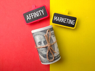 Banknotes and colored board with text AFFINITY MARKERTING on colored background.