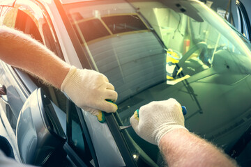 Service worker dismantle broken glass windscreen or windshield before installing new one on car in...