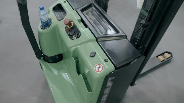 New modern powerful manual hydraulic stacker with electric lift function presented at the exhibition. The stacker is moved manually, lifting with an electric motor. Shot in motion
