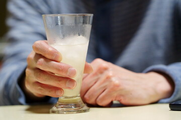 酒のグラスを持つ手元　飲酒する男性