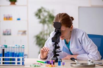 Young female chemist in drugs synthesis concept