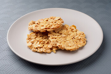 Florentina's macaroons. Almond petal cookies on a plate. Gray background.