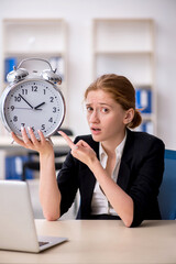 Young female employee in time management concept