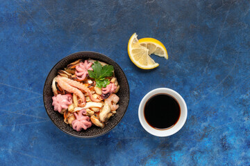 Mix of sea food - mussels, squid, octopus, shrimp in a bowl, lemon and soy sauce. Top view.