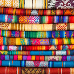 Pile of colorful indigenous Andes textiles or fabric, Otavalo market near Quito, Ecuador.