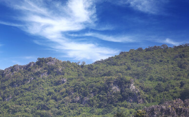 Naklejka premium Mountain in the daytime with bright white clouds.