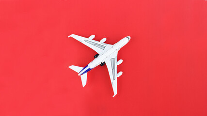  toy - airplane stand on a red paper background. Modern airplane isolated on a red background. Travel and transportation idea.