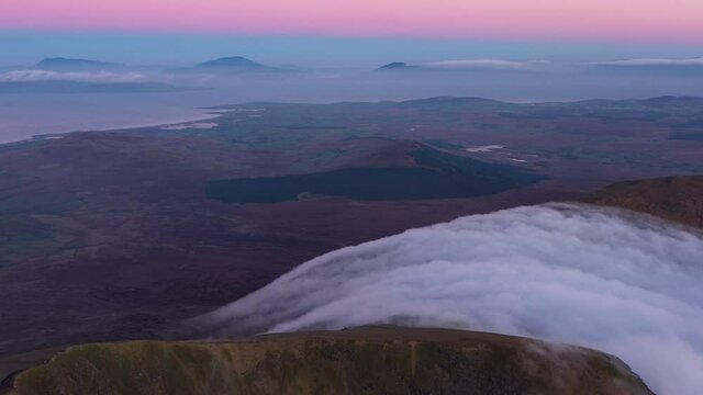 Sunrise on a mountain top with rolling clouds and cloud inversion