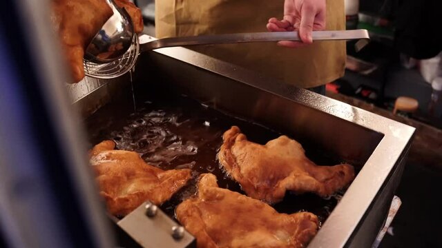 Food truck chef deep frying pizza in oil at local festival fair