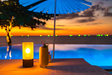 Sunset at the edge of a swimming pool at Kata beach in Phuket province, in Thailand