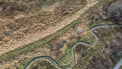 Aerial of spiraling river next to trail