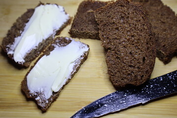 Sandwich with butter. Bread on the board cut into slices