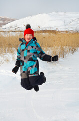 Fototapeta na wymiar caucasian child in winter clothing playing outdoors.