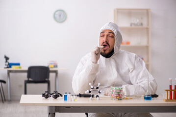 Young male chemist in drugs synthesis concept