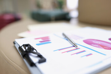 A folder with documents lies on a leather surface