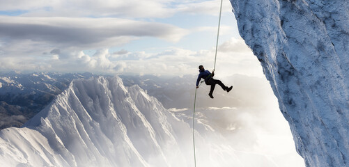 Adult adventurous man rappelling down a rocky cliff. Extreme adventure composite. 3d rendering mountain artwork. Aerial background landscape from British Columbia, Canada. - obrazy, fototapety, plakaty
