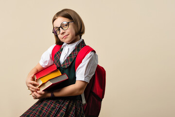 Nerd Girl 9s Wearing school uniform and in stylish round glasses. Child holding 3 textbooks indoor...