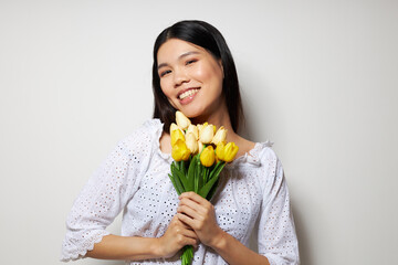 Portrait Asian beautiful young woman with a bouquet of flowers smile close-up studio model unaltered