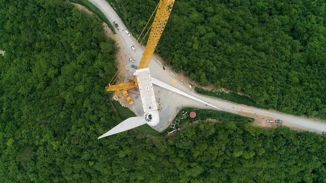 energy, Blade hangs on crane hook at wind turbine construction site. Timelapse. 풍력발전기, 풍력터빈 설치, 블레이드 설치.