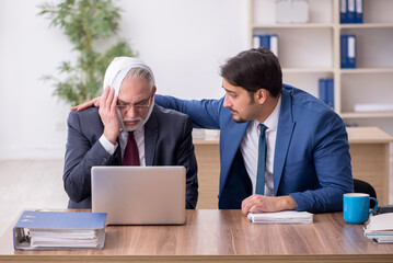 Old male employee suffering from toothache in the office