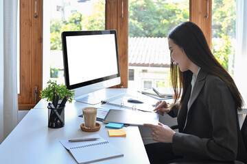 Obraz na płótnie Canvas Beautiful business woman analyzing financial document at her workplace.