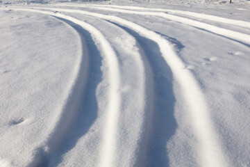 Trail from a car in the snow in winter.
