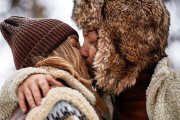 Young couple hugging and kissing in the Park in winter