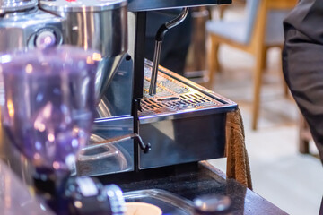 modern metallic stainless steel coffee maker or espresso machine at the cafe kitchen with warm and...