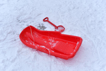 Red sled and shovel in the snow