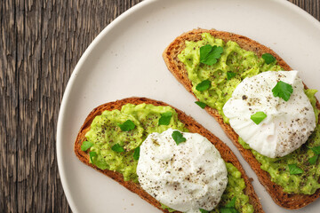 Top view avocado toast with poached egg in plate