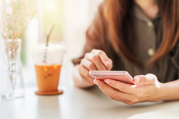 Young woman with drinks using mobile phone and relaxing in cafe, Modern lifestyle