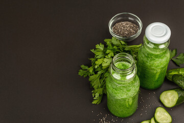 Green smoothie with cucumber in glass bottles. Fresh ripe vegetables, greens, and chia seeds