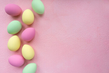 Easter flat lay. Eggs painted in pastel colors on pink background, space for text