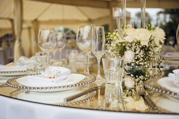 Luxurious restaurant. Luxurious interior, white tables, serving dishes and glasses for guests