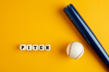 Wooden baseball bat and a ball on yellow background with the word pitch.