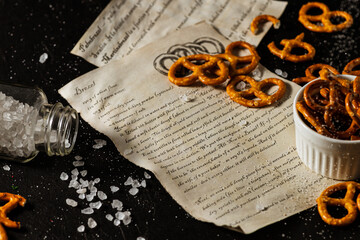 the recipe for making pretzels is written on a piece of paper, next to it lies salt and pretzels